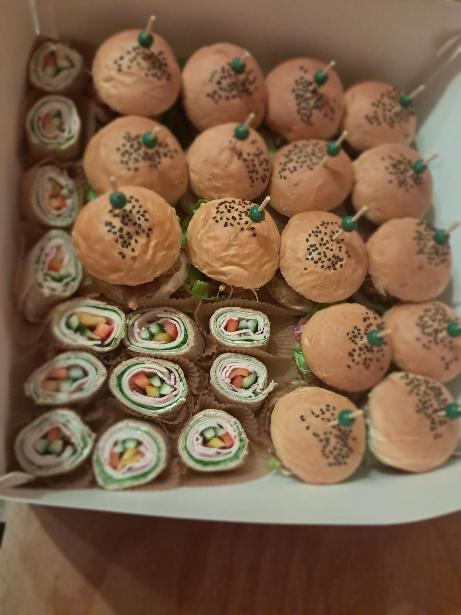 Box cateringowy finger food: mini burgery z zielonymi wykałaczkami i roladkami z tortilli – catering BC Mobile Chef